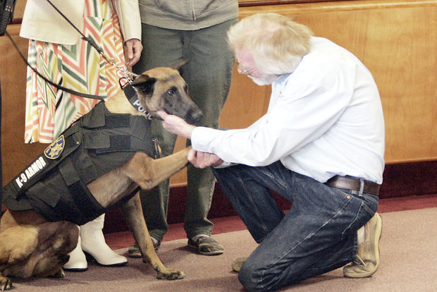 Napa PD K9 Rocky shakes paws with Thomas Hundley, owner of Spinnaker Electric to say thank you for donating to K9Armor.com